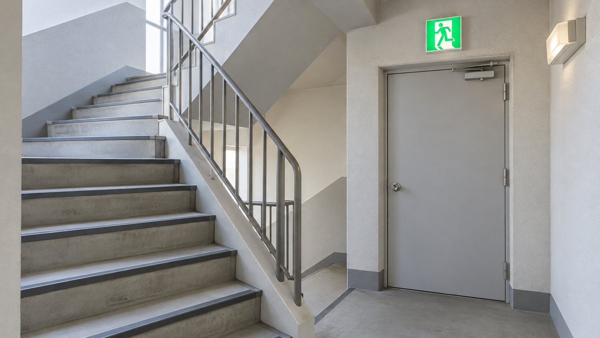 手すりと非常用の照明がある屋内の避難階段